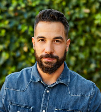 A man with a beard wearing a denim shirt