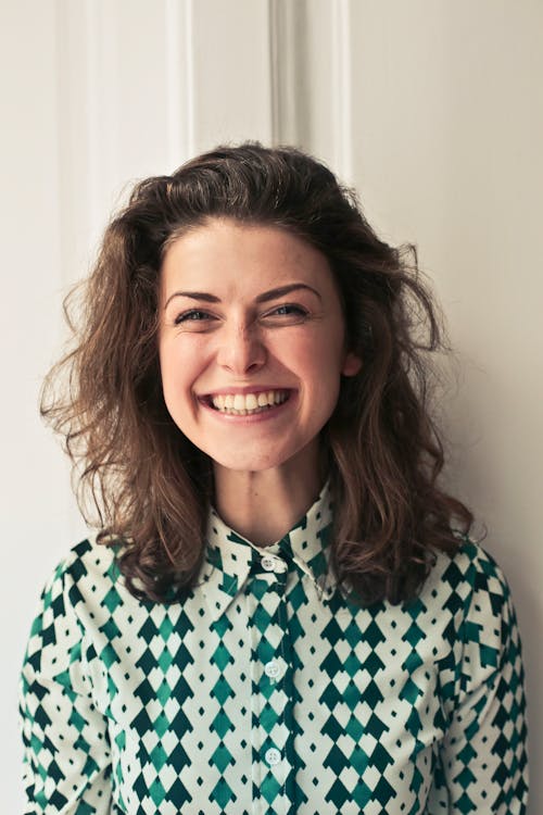 A smiling woman in a green and white shirt